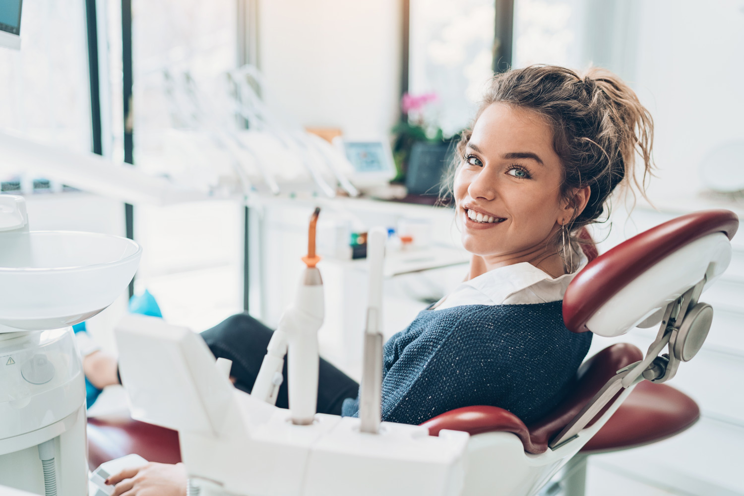 Brunette woman in a dental chair smiles in Harrisonburg, VA, after her full mouth reconstruction