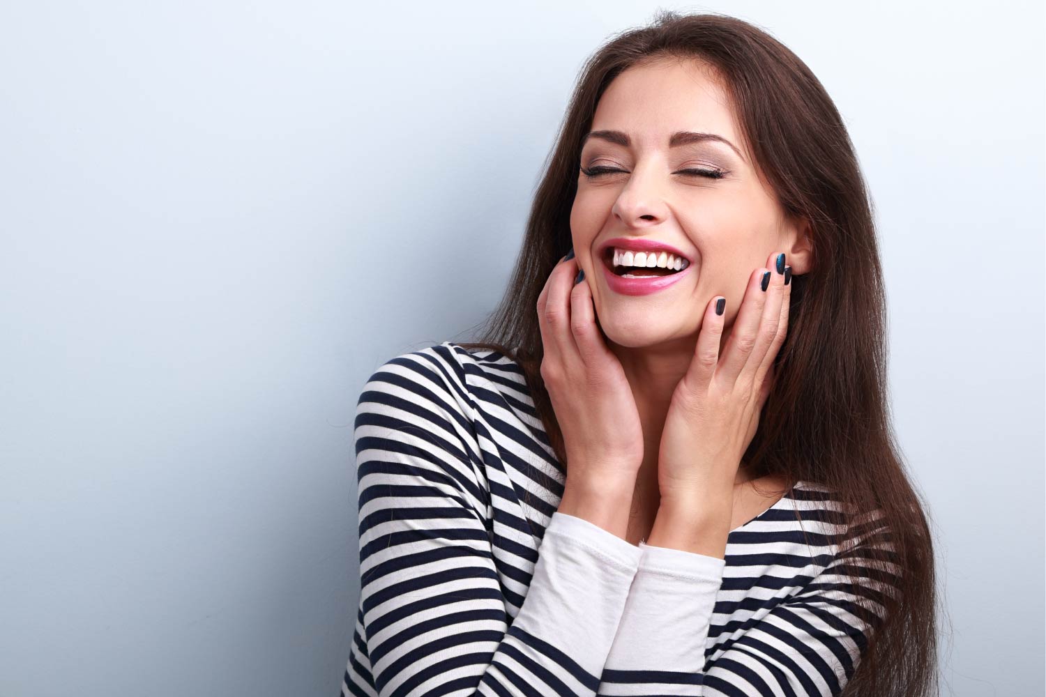 Brunette woman in a striped shirt smiles after straightening her teeth with clear aligners in Harrisonburg, VA