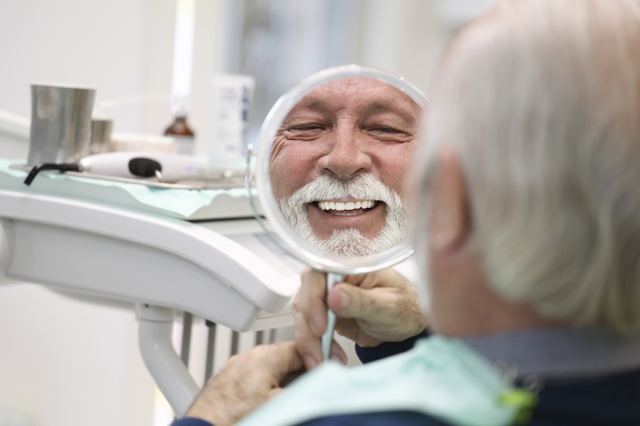 full mouth restoration, man looking at dental work
